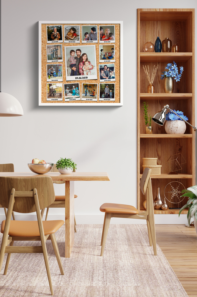 Collage di famiglia con istantanee datate, fondo in sughero e cornice bianca accanto a una libreria in sala da pranzo