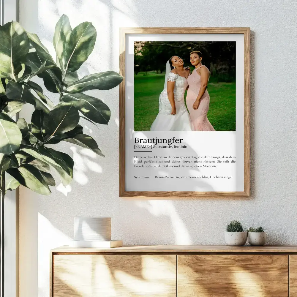 Brautjungfer-Definitionsposter mit einem Hochzeitsfoto im Naturholzrahmen an der Wand über einer Kommode