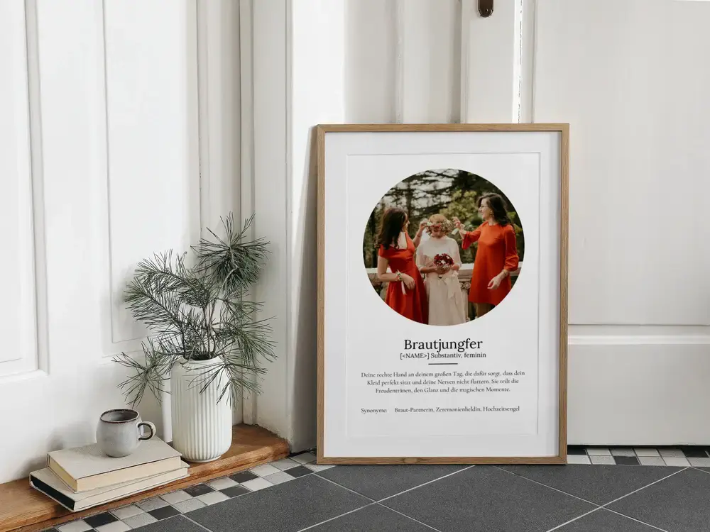 Brautjungfer-Definitionsposter mit rundem Foto im Naturholzrahmen, am Boden an eine weisse Wand gelehnt