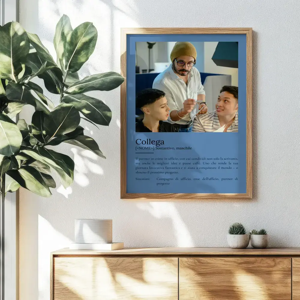 Poster azzurro con foto e testo in stile dizionario, in cornice di legno sopra una credenza accanto a una pianta
