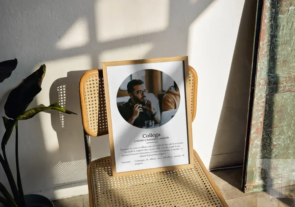 Poster con foto circolare e definizione, in cornice di legno appoggiata su una sedia in paglia al sole