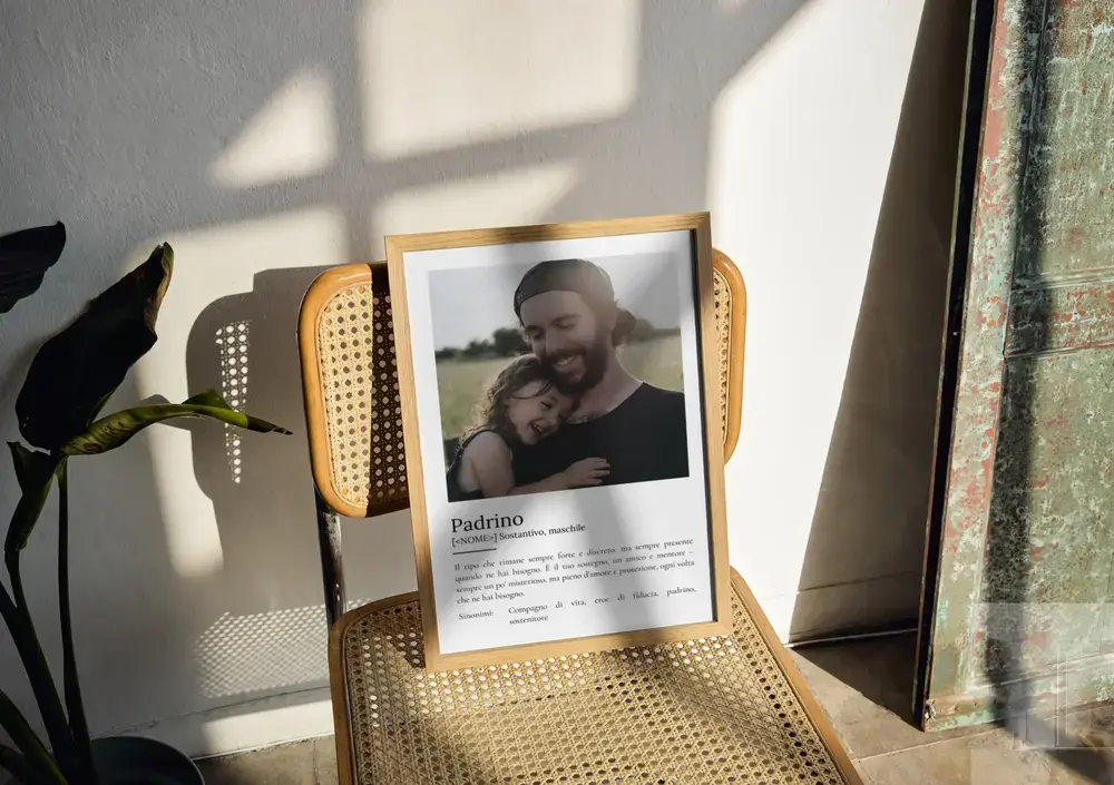 Poster personalizzato per il padrino con foto e definizione, in cornice di legno appoggiata su una sedia