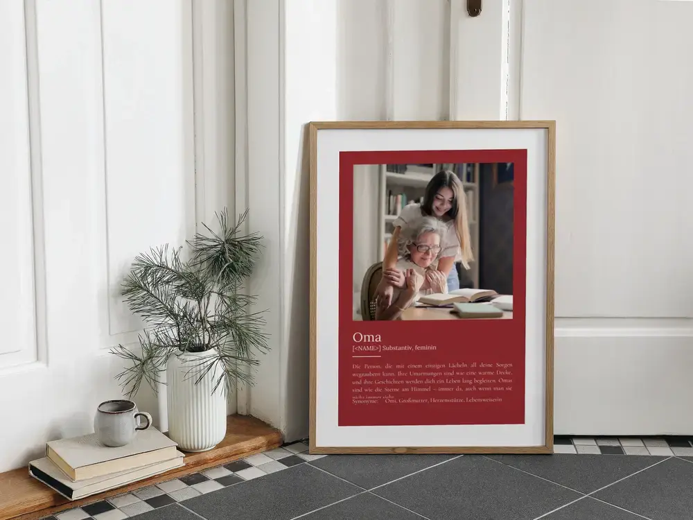 Weinrotes Foto-Definitionsposter im Naturholzrahmen, am Boden neben einer Pflanze, als Geburtstagsgeschenk für Oma