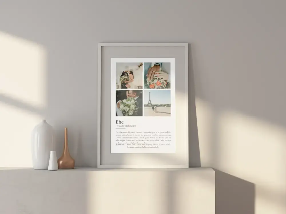 Definitionsposter zur Ehe mit vier Fotos von Brautpaar, Ringen und Blumen im weissen Rahmen auf einem hellen Sideboard