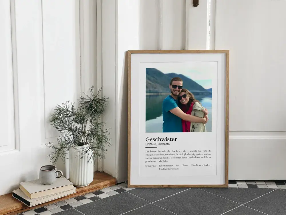 Geschenkidee für Geschwister: Definitionsposter mit einem Foto im Holzrahmen, am Boden neben einer Pflanze