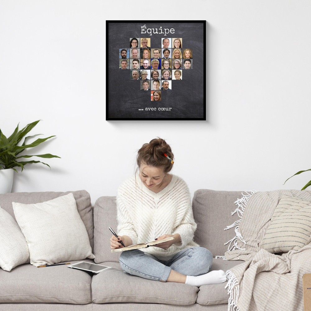 Collage de portraits d’équipe en forme de cœur, dans un cadre noir au-dessus d’un canapé gris
