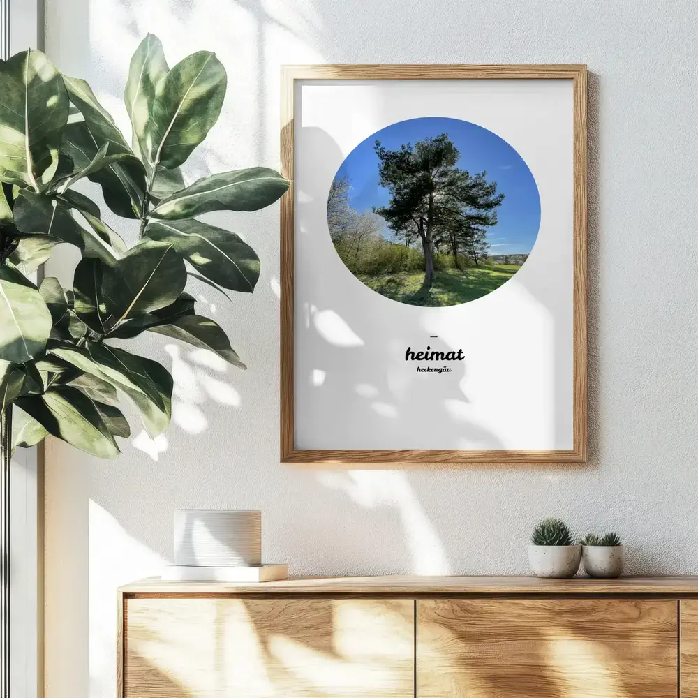 Personalisiertes Heimat-Poster mit rundem Naturfoto im Holzrahmen über einer Kommode neben einer Zimmerpflanze