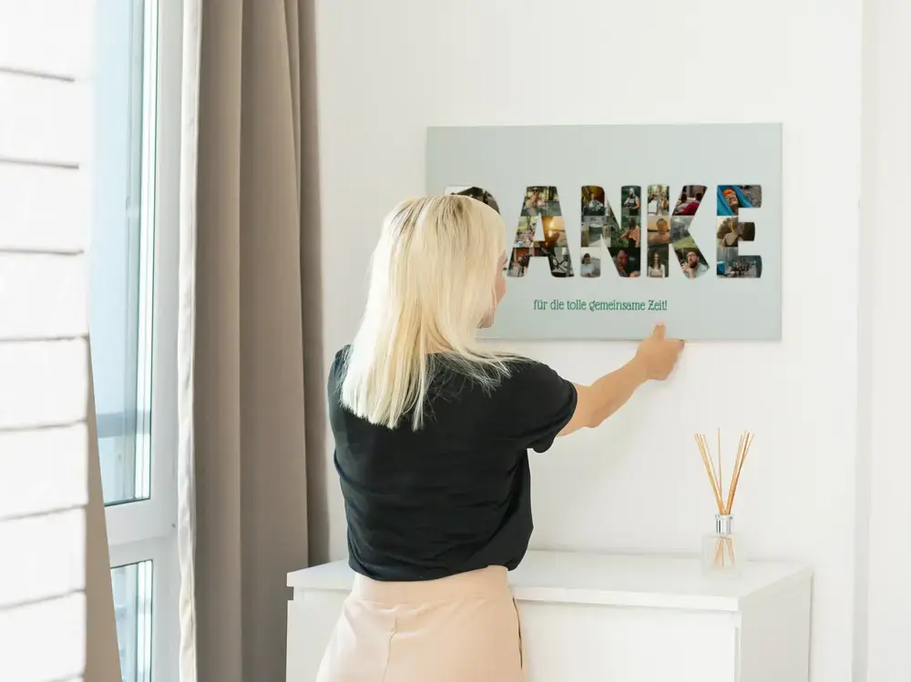 Fotocollage-Poster mit Buchstaben aus Fotos als Jubiläumsgeschenk, an heller Wand über einer weissen Kommode