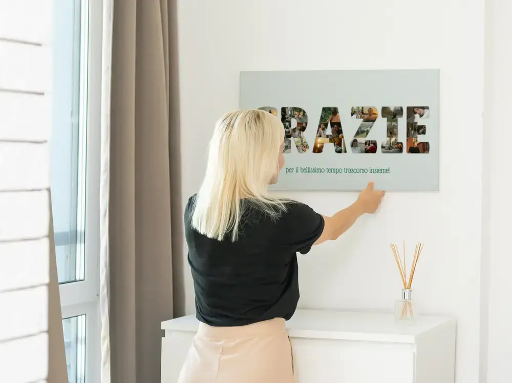 Poster con lettere composte da foto e dedica sulla parete sopra una consolle, idea regalo per un anniversario