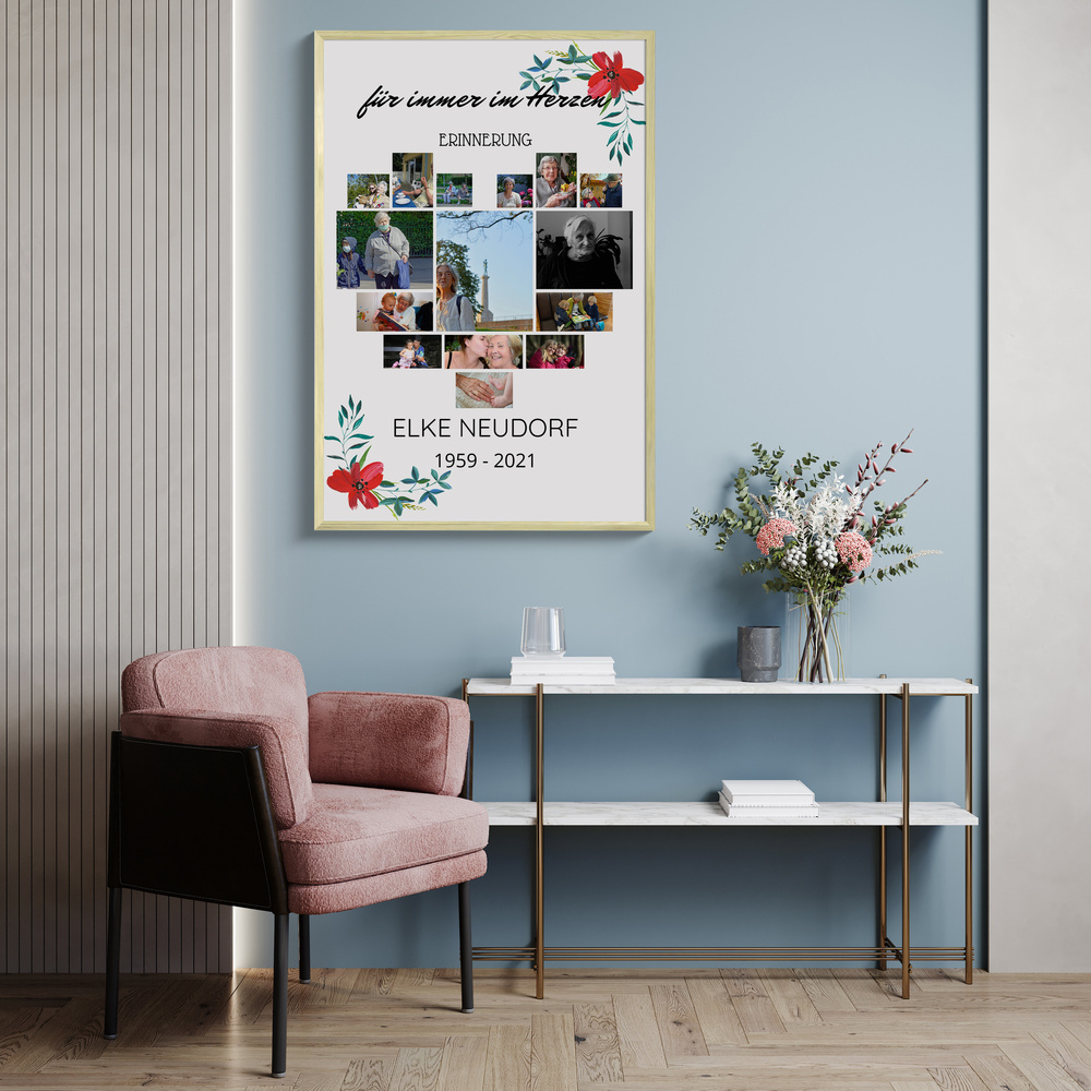 Trauercollage mit Fotoherz und Blumen im hellen Rahmen an blauer Wohnzimmerwand über einem Konsolentisch