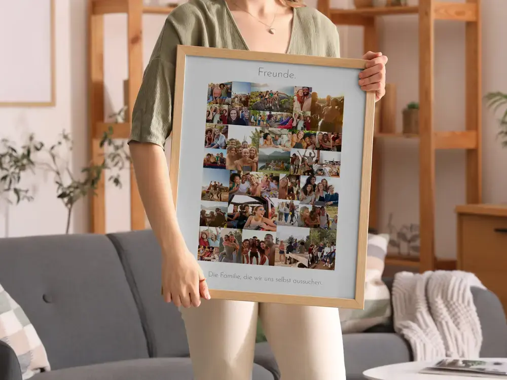 Fotocollage mit Freundschaftsspruch und vielen Fotos im hellen Holzrahmen, präsentiert vor einem grauen Sofa im Wohnzimmer