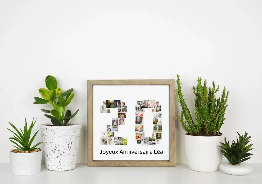 Collage photo 20 ans dans un cadre en bois clair, posé sur un bureau blanc entre des plantes vertes