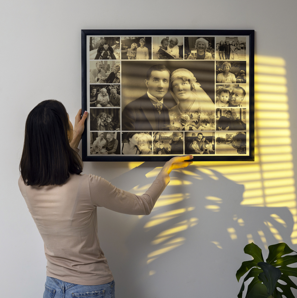 Collage photo commémoratif sépia en cadre noir, avec grand portrait de mariage, sur un mur strié de soleil